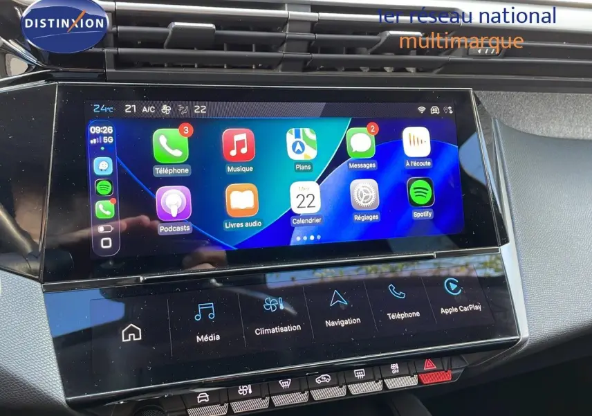 Écran tactile central de la Peugeot 308 2024 en bleu obsession, affichant Apple CarPlay et commandes climatisation.