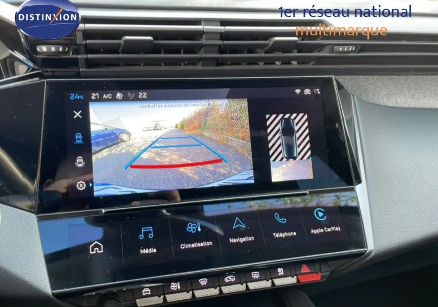 Vue rapprochée de l'écran tactile intérieur de la Peugeot 308 2024 bleu obsession, affichant la caméra de recul et les commandes multimédia.