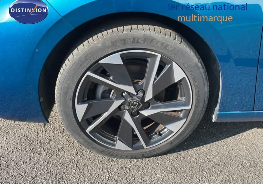 Gros plan sur la roue avant gauche de la Peugeot 308 bleu obsession métal avec jante alliage bicolore 2024.