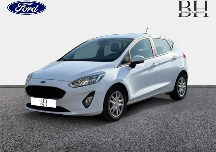 Ford Fiesta blanc glacier vue 3/4 avant droit, avec calandre noire et jantes alliage visibles.