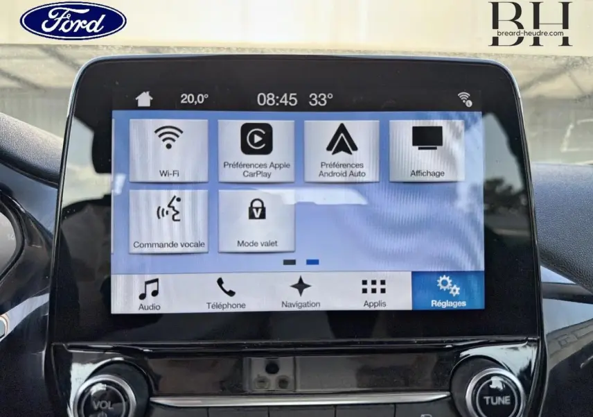 Écran tactile central de la Ford Fiesta 2018 affichant les réglages connectés, avec commandes vocales et navigation visibles.