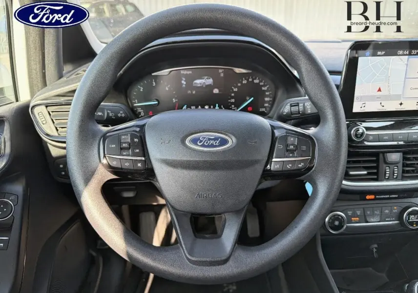 Vue intérieure centrée sur le volant noir de la Ford Fiesta 2018 avec tableau de bord numérique et écran tactile GPS.