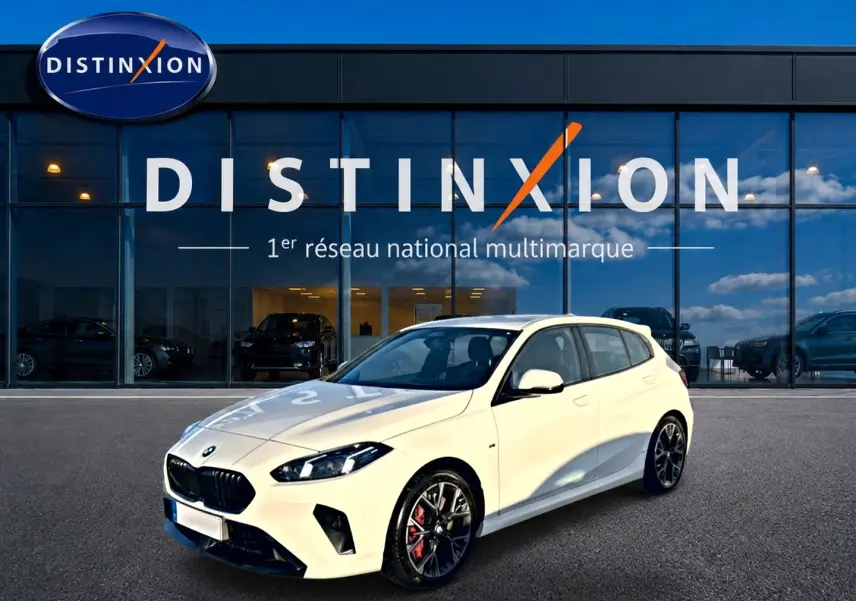 BMW Série 1 blanc alpin vue 3/4 avant droit, jantes 18 pouces bicolores et calandre noire M Sport.