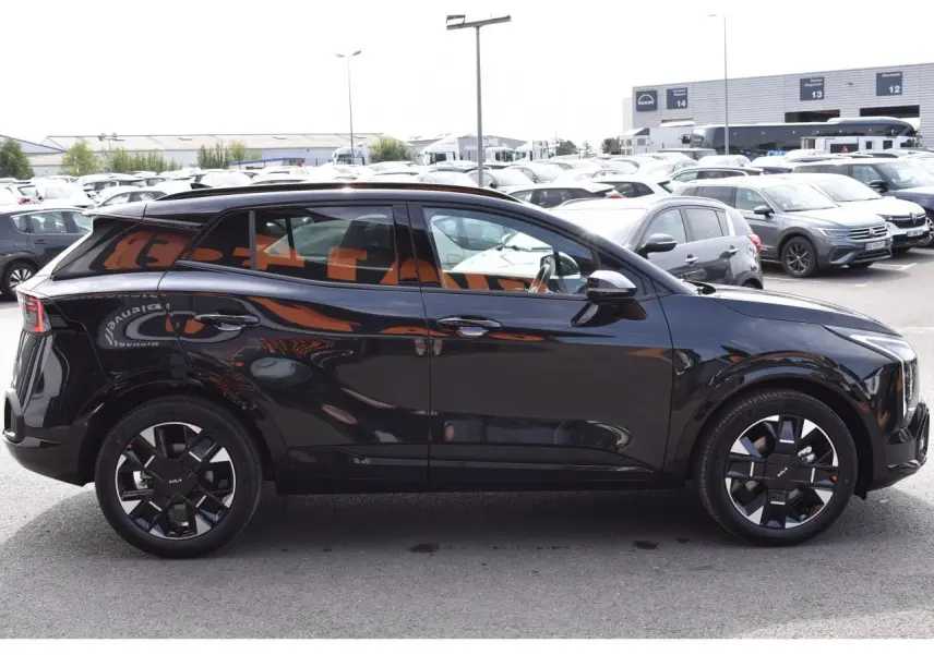 Vue de profil côté gauche d'un Kia Sportage noir 2026 avec jantes 19 pouces au design moderne.