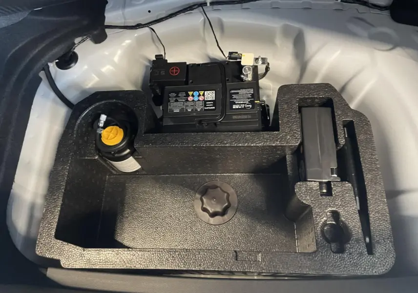 Vue plongeante sur le coffre blanc du MG3 1.5 Hybrid+ 2026, montrant la batterie et le rangement en mousse noire.