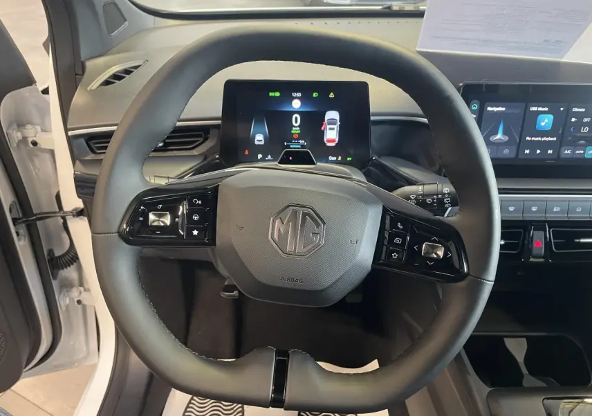 Vue frontale du volant noir de la MG3 1.5 Hybrid+ 195 Luxury blanche, avec tableau de bord numérique et écran tactile visible.