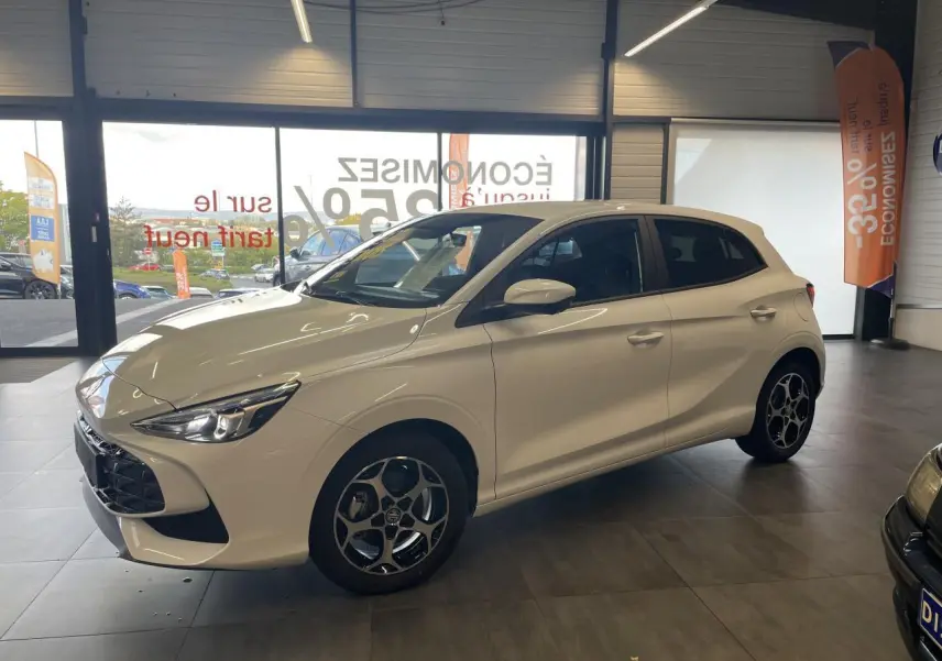 Vue 3/4 avant droite d'une MG3 blanche 2026 avec jantes alliage et vitres surteintées en showroom.