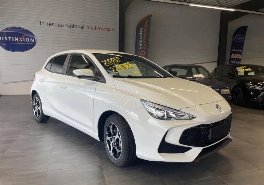Vue 3/4 avant d'une MG3 1.5 Hybrid+ blanche avec jantes alliage 16'' dans un showroom intérieur.