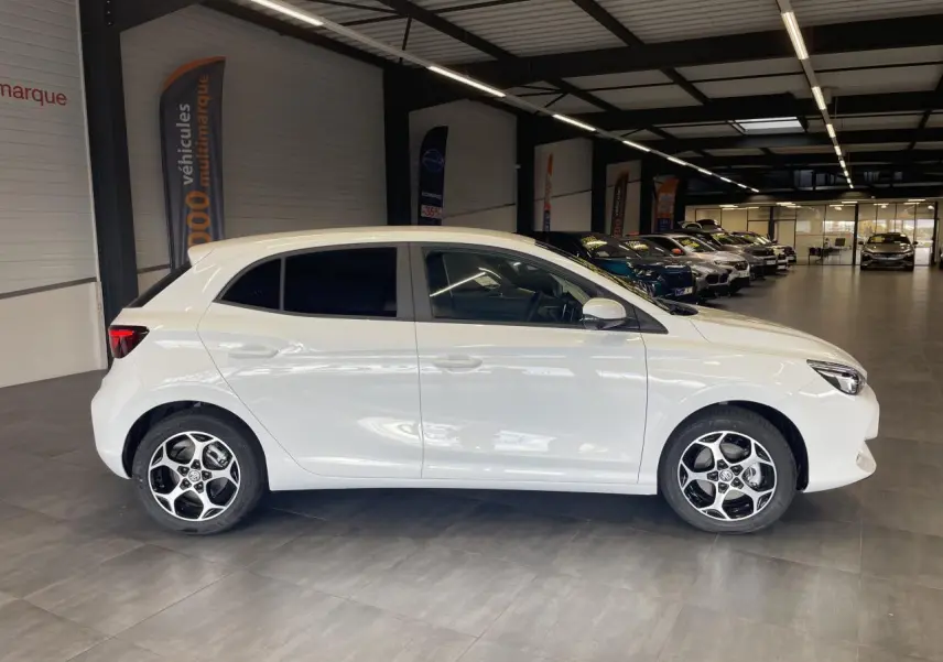 Vue de profil côté gauche d’une MG3 1.5 Hybrid+ blanche avec jantes alliage 16 pouces en showroom.
