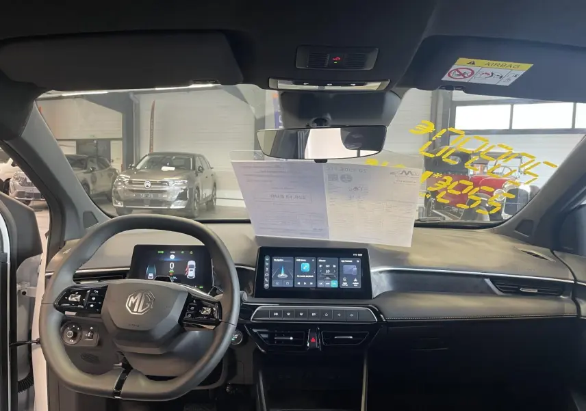 Vue intérieure avant du tableau de bord du MG3 1.5 Hybrid+ 2026 avec écran tactile et volant multifonction noir.