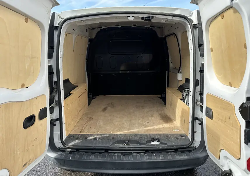 Vue arrière du Nissan NV250 blanc 2020 avec portes ouvertes montrant l'espace de chargement en bois.