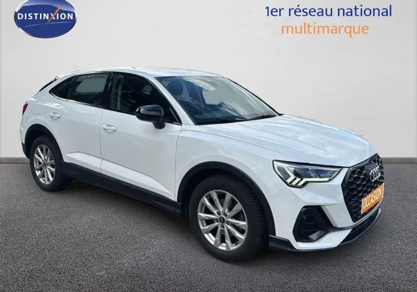 Audi Q3 Sportback blanc en 3/4 avant droit, avec calandre noire et jantes alliage visibles.