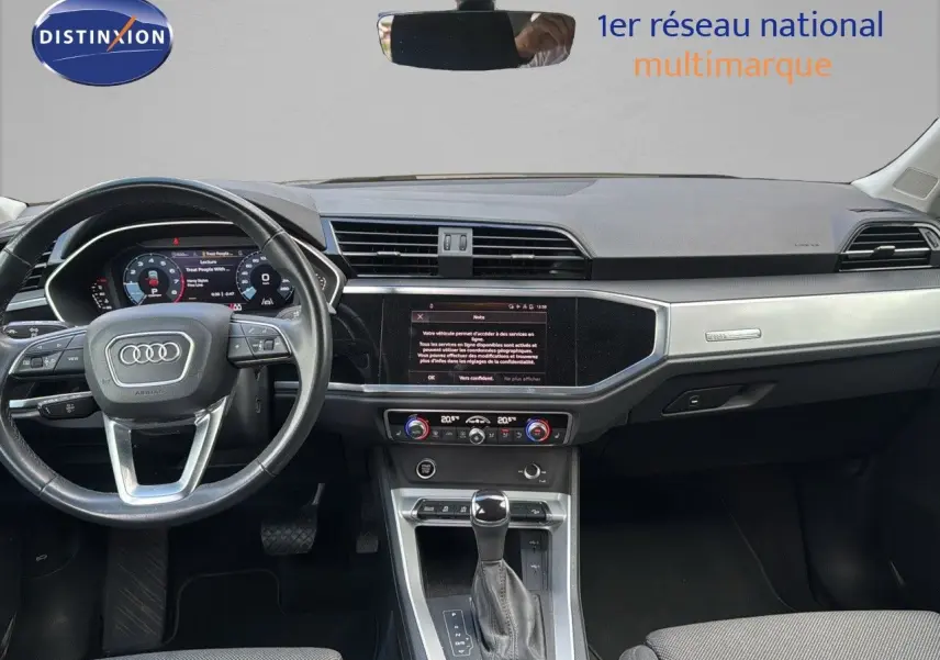Intérieur d'Audi Q3 Sportback blanc 2021, vue frontale du tableau de bord avec écran tactile et volant multifonction.