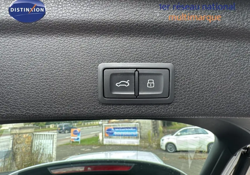 Boutons d'ouverture et de verrouillage du hayon sur la garniture intérieure du coffre d'un Audi Q3 Sportback blanc.