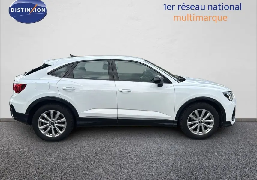Audi Q3 Sportback blanc vu de profil côté gauche, soulignant sa silhouette dynamique et ses jantes alliage.