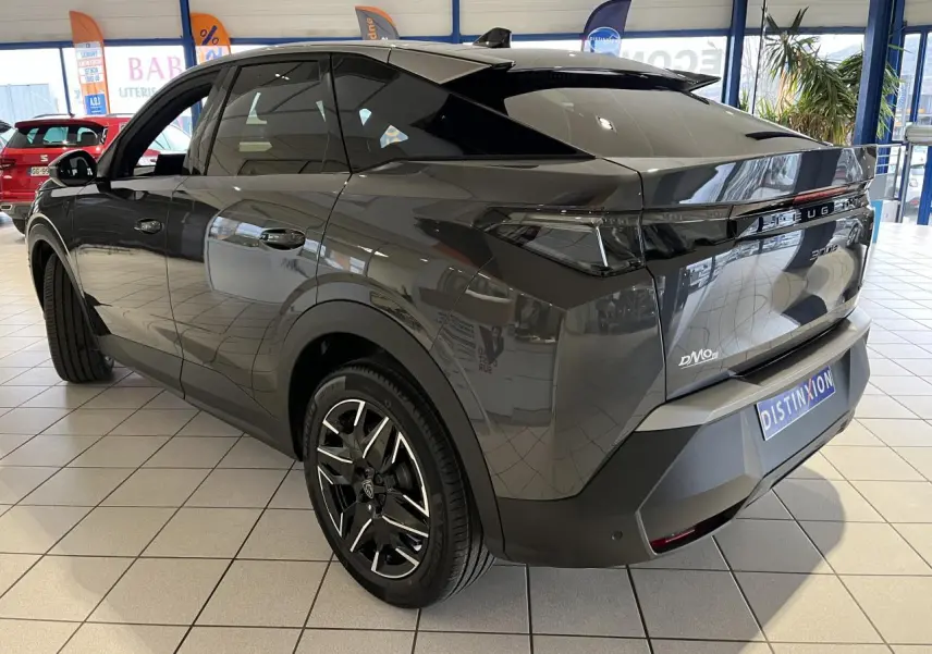 Vue 3/4 arrière droite du Peugeot 3008 gris titanium avec jantes alliage 19'' et bandeau noir laqué entre feux arrière.