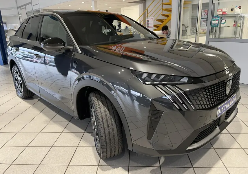 Peugeot 3008 gris titanium en 3/4 avant droit, avec calandre noire et feux LED griffés distinctifs.