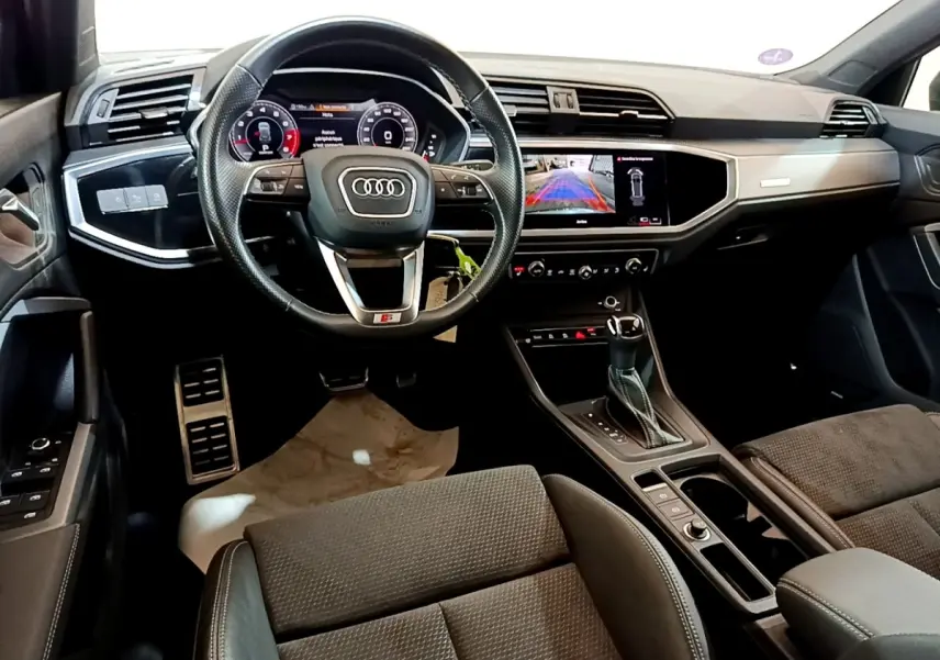 Intérieur Audi Q3 35 TFSI S Line 2022, vue avant centrée sur volant cuir et tableau de bord digital avec écran tactile.