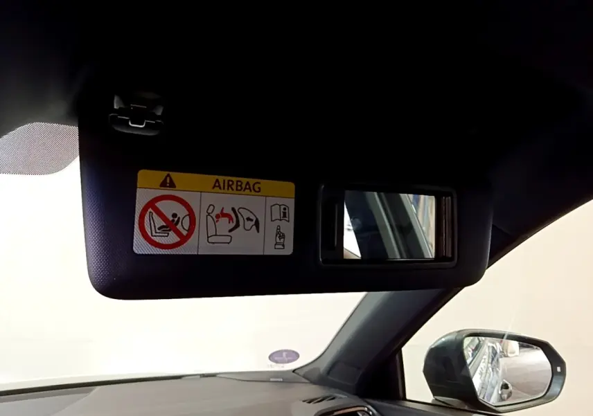 Détail du pare-soleil côté conducteur avec miroir intégré et avertissement airbag dans l’Audi Q3 gris foncé 2022.