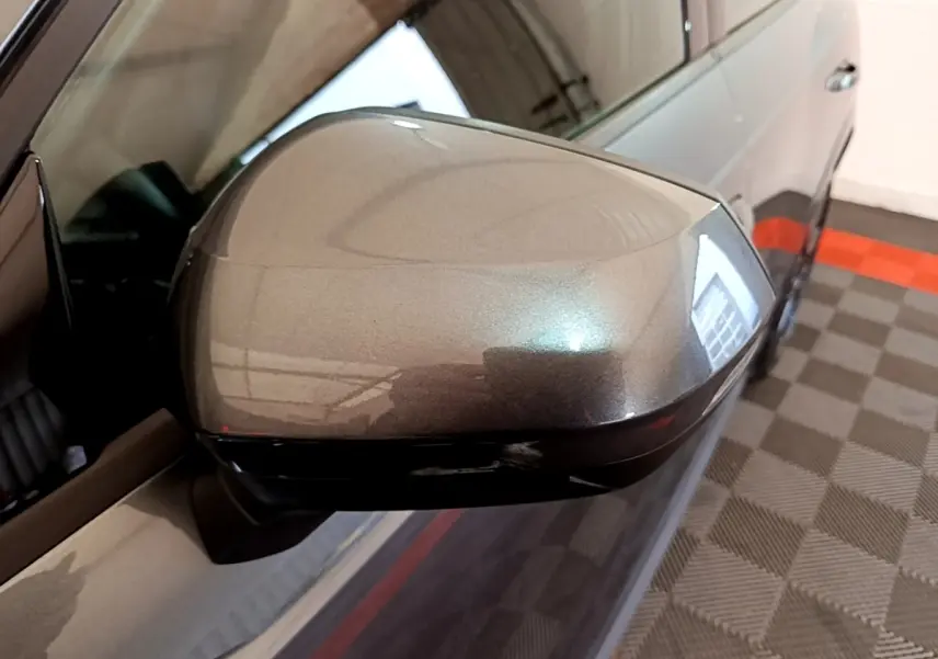 Rétroviseur côté gauche gris foncé d'un Audi Q3 35 TFSI S Line 2022, avec carrosserie partiellement visible en intérieur.