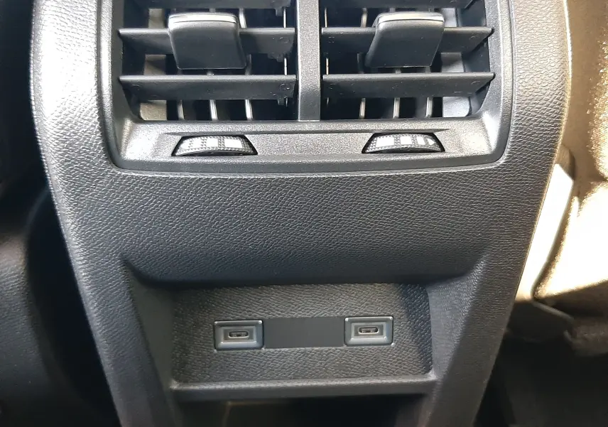 Gros plan sur la console arrière de la Peugeot 308 Bleu Obsession 2026, montrant les aérateurs et deux ports USB.