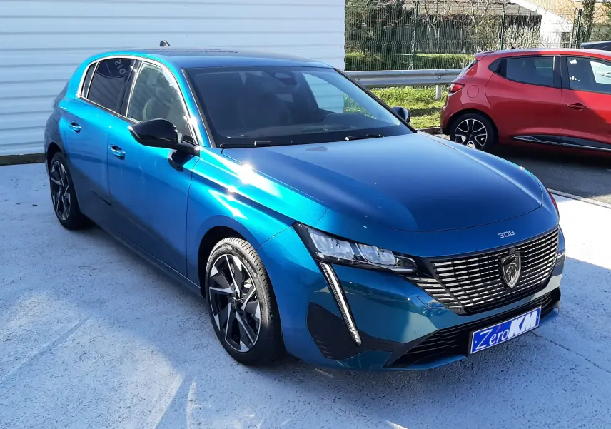 Peugeot 308 Bleu Obsession vue 3/4 avant droit, mettant en valeur sa calandre distinctive et ses jantes alliage.