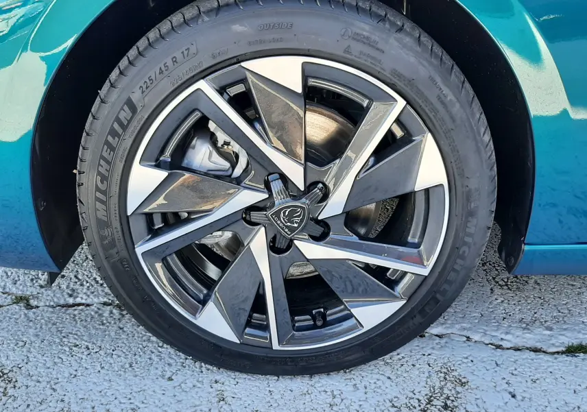 Gros plan sur la roue avant droite d'une Peugeot 308 Bleu Obsession avec jante alliage bicolore et pneu Michelin.