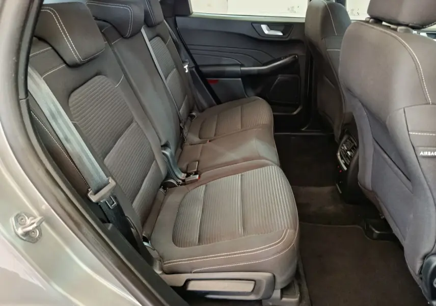 Vue intérieure côté gauche des sièges arrière en tissu gris foncé du Ford Kuga 2023 version hybride Titanium.