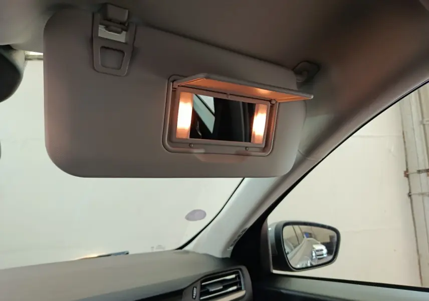 Détail intérieur du pare-soleil avec miroir éclairé côté conducteur du Ford Kuga gris foncé 2023.