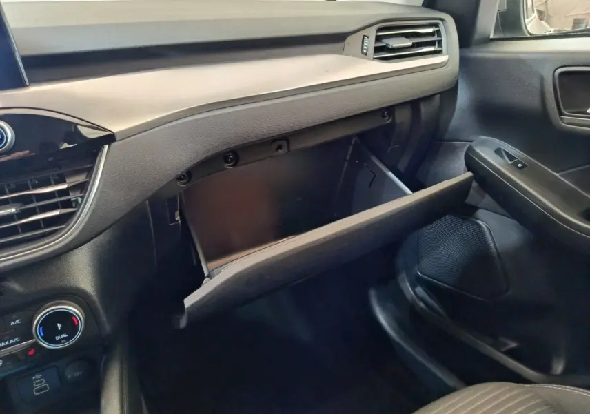 Vue intérieure côté passager du tableau de bord noir et gris avec boîte à gants ouverte du Ford Kuga 2023.