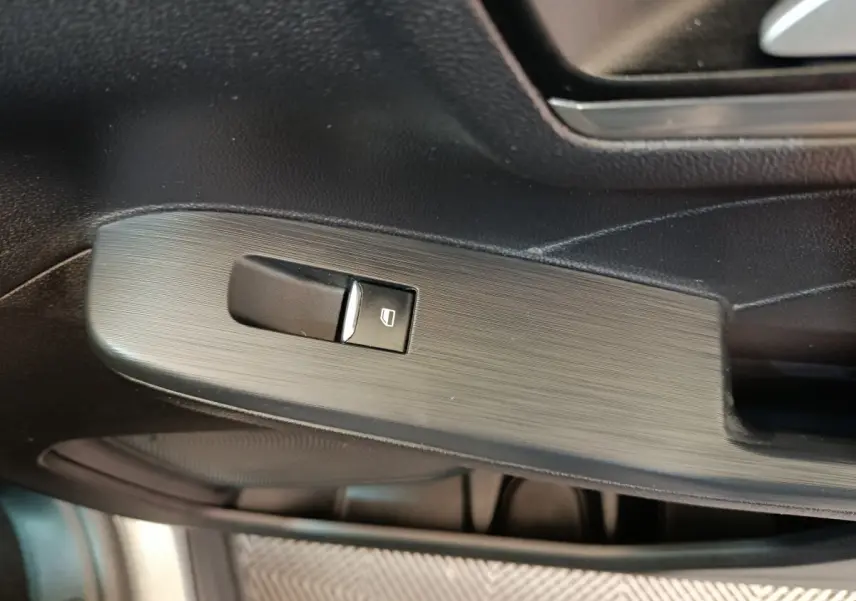 Gros plan sur la commande de lève-vitre côté conducteur du Ford Kuga gris foncé, finition Titanium 2023.