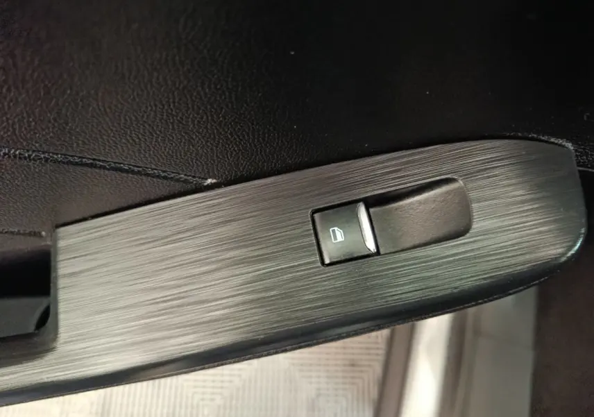 Gros plan sur l'interrupteur de lève-vitre côté conducteur du Ford Kuga gris foncé 2023, finition Titanium.