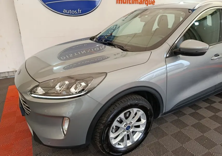 Vue 3/4 avant droit d’un Ford Kuga gris foncé 2023 avec jantes alliage et phares LED ellipsoïdaux.