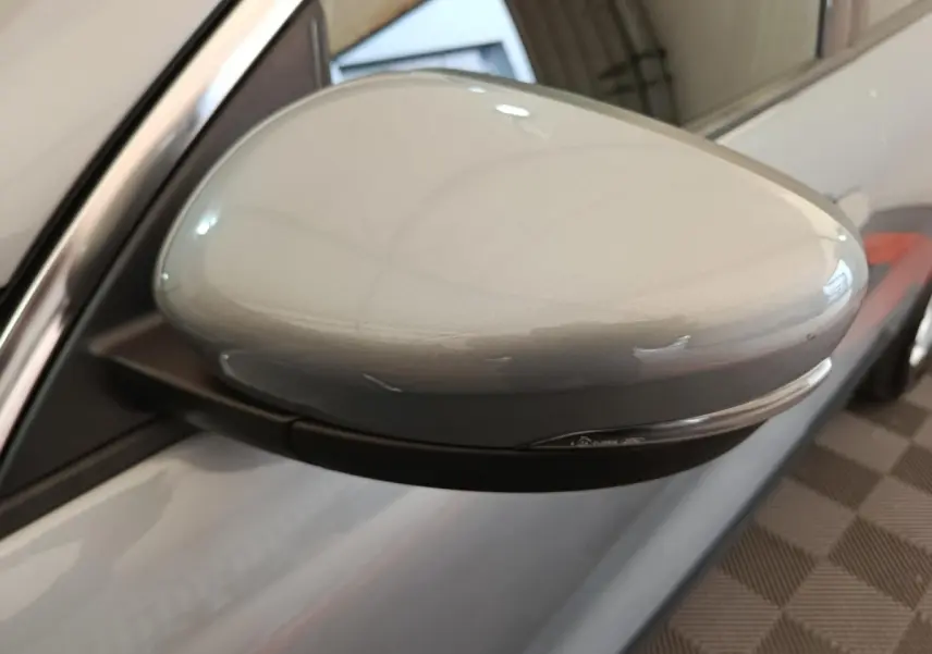 Rétroviseur côté gauche gris foncé du Ford Kuga 2023 avec clignotant intégré, vue rapprochée en intérieur.