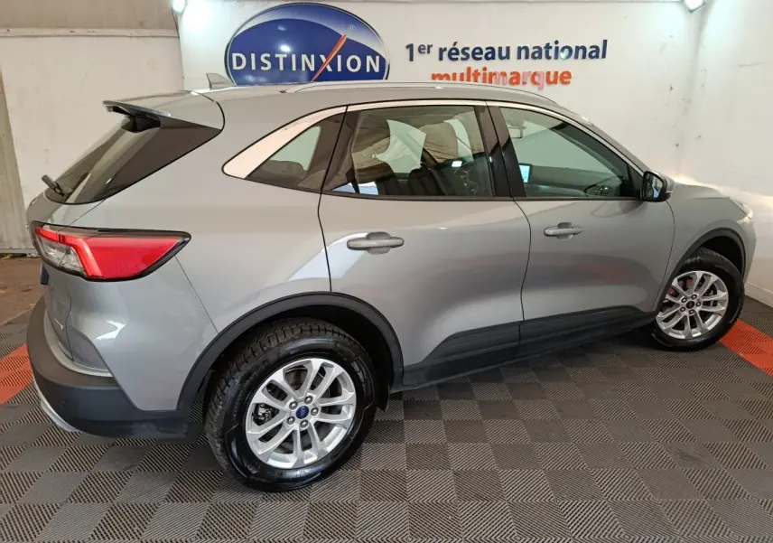 Vue latérale droite d'un Ford Kuga 2.5 Hybrid gris foncé 2023 avec jantes alliage et rails de toit chromés.