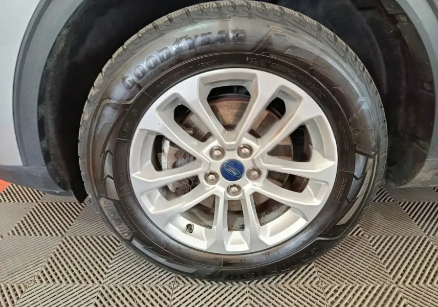 Gros plan sur la roue avant gauche du Ford Kuga gris foncé, avec jante alliage et pneu Goodyear visible.