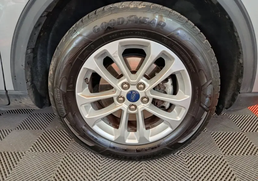 Gros plan sur la roue avant droite gris foncé du Ford Kuga 2.5 190 hybrid Flexifuel avec jante alliage et pneu Goodyear.