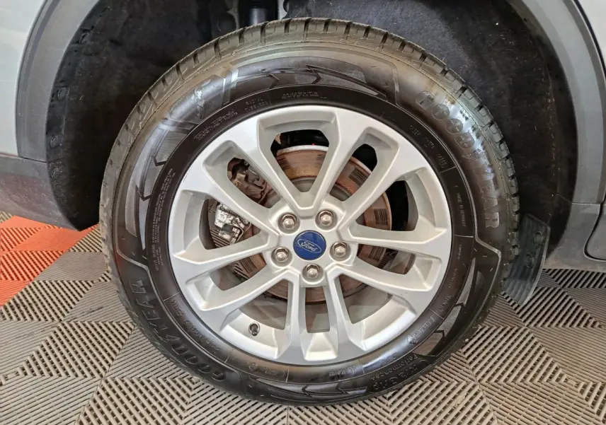 Gros plan sur la roue avant droite du Ford Kuga gris foncé, mettant en valeur la jante alliage et le pneu Goodyear.