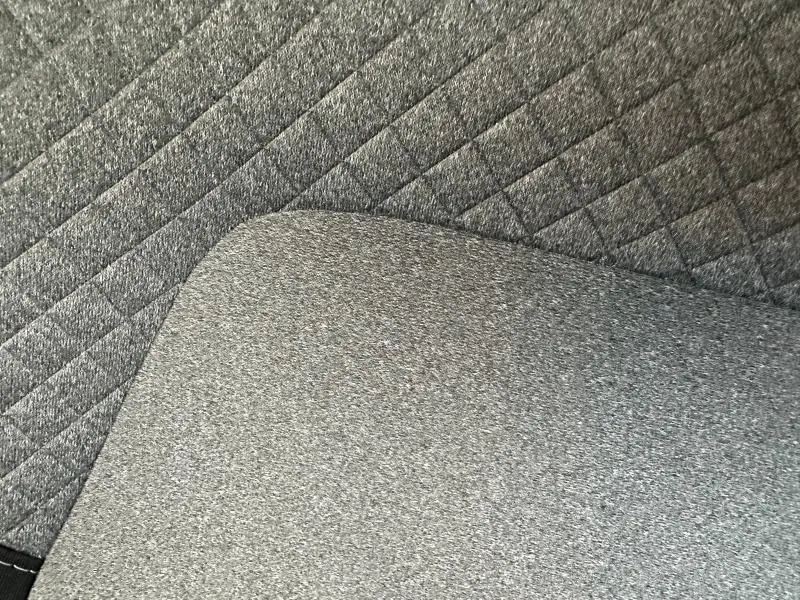 Image ne montrant pas le véhicule, mais un détail du tapis de sol intérieur gris texturé de la Renault Clio 1.0 TCe 90ch Evolution 2025.