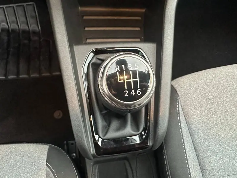 Gros plan sur le levier de vitesses manuel noir de la Renault Clio 1.0 TCe 90ch Evolution 2025, entouré de garnitures grises.