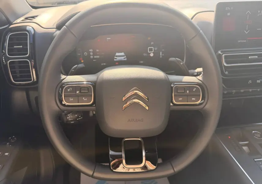Vue frontale du volant cuir noir multifonction du Citroën C5 Aircross 2025 avec tableau de bord digital et écran tactile.