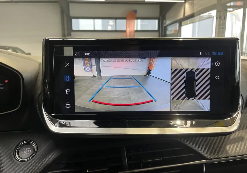 Écran tactile intérieur montrant la caméra de recul et la vue 360° du Peugeot 2008 hybride bleu, planche de bord carbone.