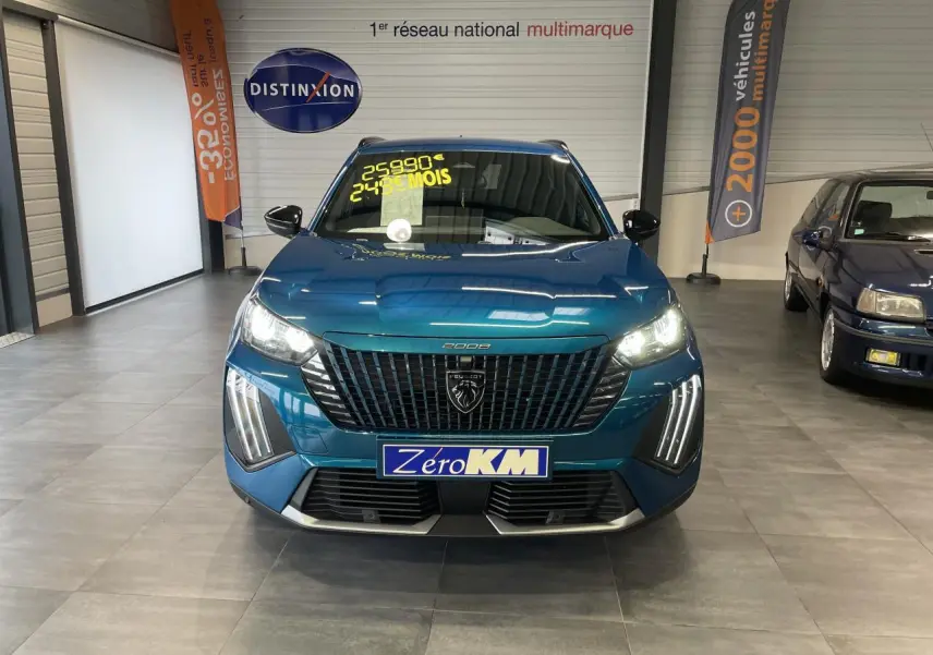 Vue frontale d'un Peugeot 2008 bleu métallisé avec feux LED allumés et calandre noire brillante en showroom.