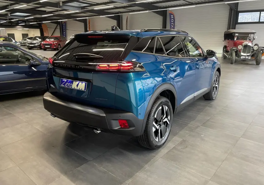 Vue 3/4 arrière droite d’un Peugeot 2008 bleu métallisé avec feux arrière à LED et jantes alliage 17 pouces.