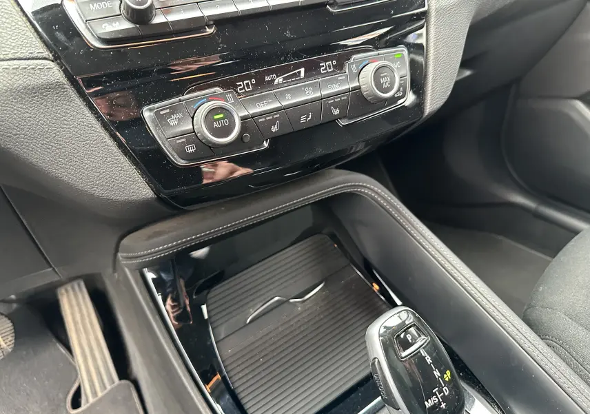 Gros plan sur la console centrale du BMW X2 gris 2018, montrant la climatisation automatique et le levier de vitesse automatique.