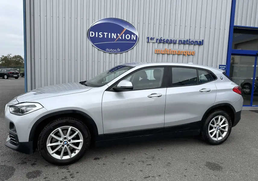 BMW X2 gris vue de profil côté gauche, mettant en valeur ses jantes alliage 17 pouces et son design compact SUV.