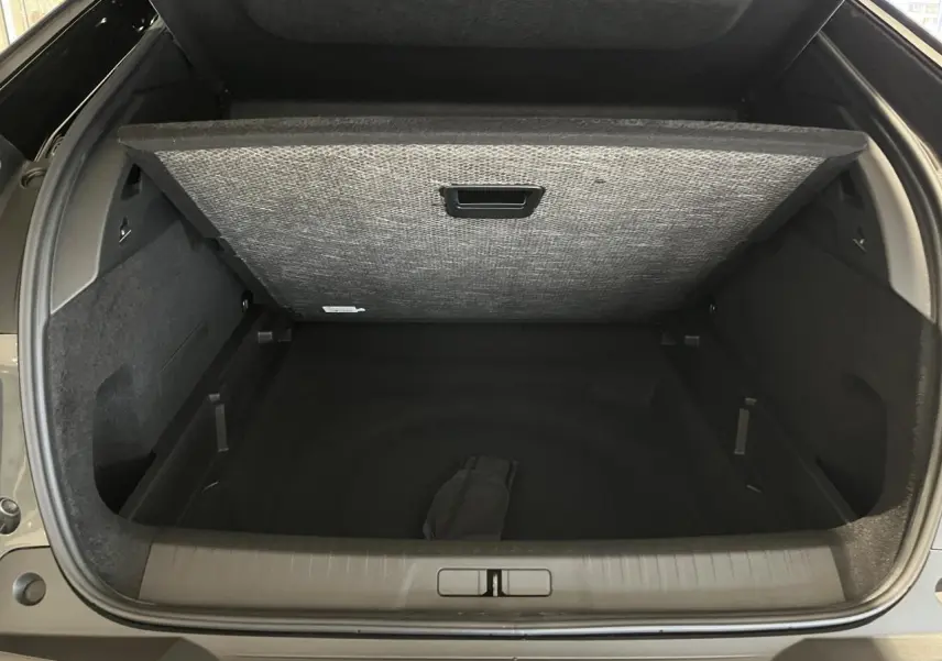 Coffre ouvert du Peugeot 3008 gris titanium, vue arrière mettant en valeur l'espace de rangement modulable.