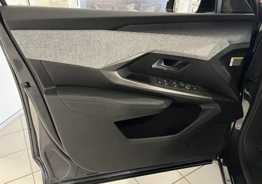 Porte intérieure côté gauche du Peugeot 3008 gris titanium, avec garniture tissu chiné et commandes de vitres intégrées.