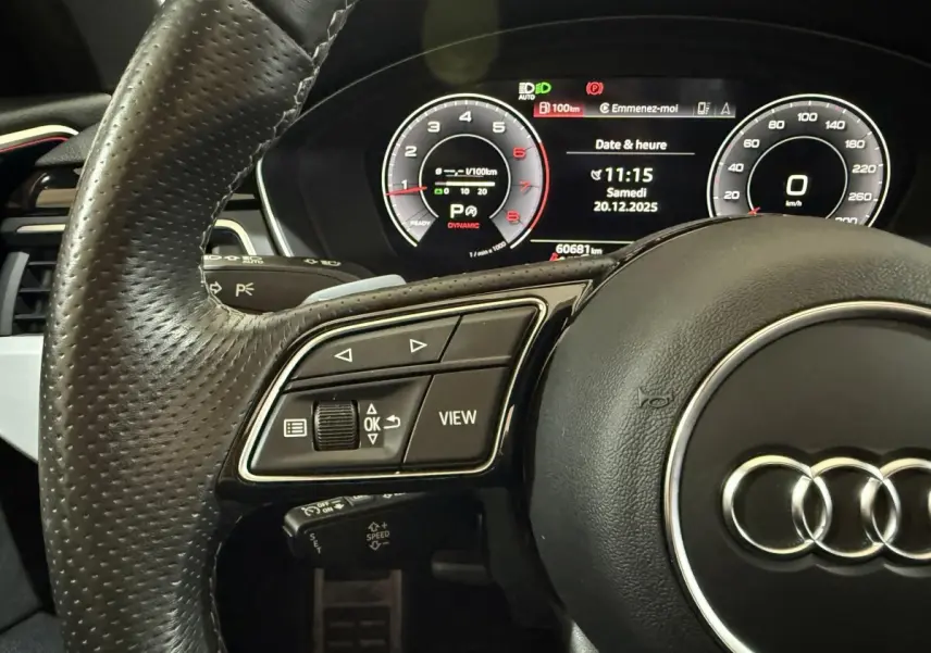 Gros plan sur le volant cuir noir d'une Audi A4 35 TFSI 2022 avec tableau de bord numérique affichant la vitesse et l'heure.