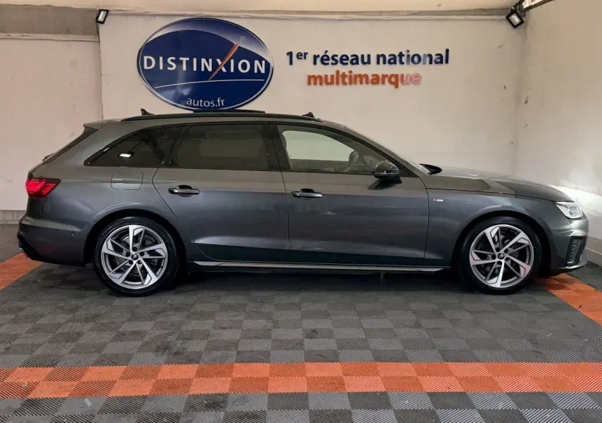Audi A4 35 TFSI S Edition gris foncé vue de profil côté gauche dans un garage avec jantes alliage et toit ouvrant.